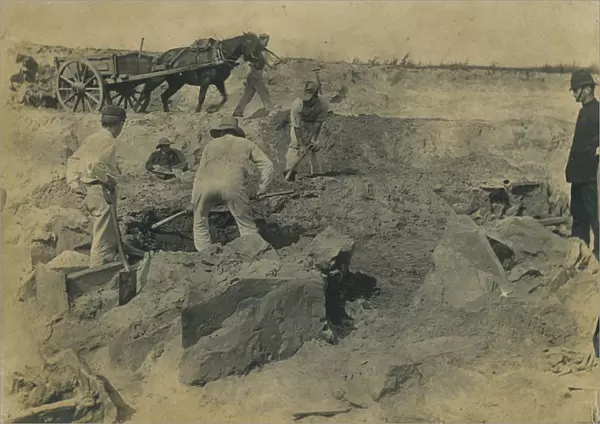 Workmen uncovering a group of cists at the excavation site of the Iron Age cemetery at Harlyn Bay, St Merryn, Cornwall. 1900