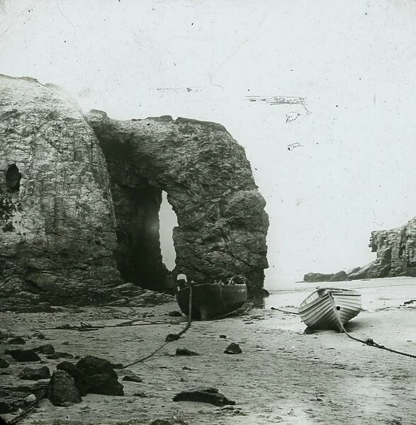 Perranporth Arch Rock, with boats on the beach, Cornwall. Around 1925