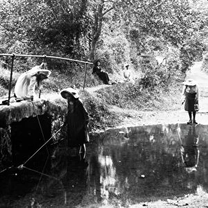 Three girls fishing in the River Kenwyn at the ford and footbridge, Treliske Lane, Newmills, Kenwyn, Cornwall. Early 1900s