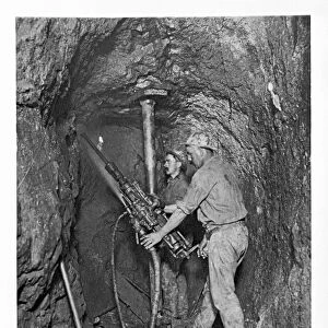 Two miners drilling with dust laying spray. King Edward Mine, South Condurrow, Camborne, Cornwall. Around 1900