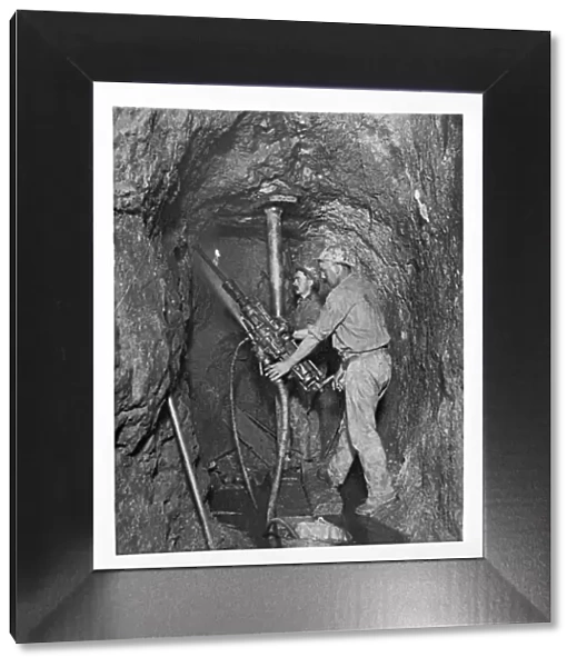 Two miners drilling with dust laying spray. King Edward Mine, South Condurrow, Camborne, Cornwall. Around 1900