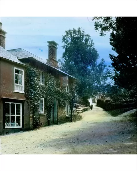 The Falcon Inn and view up hill with a postman walking towards the camera. St Mawgan in Pydar, Cornwall. Around 1925