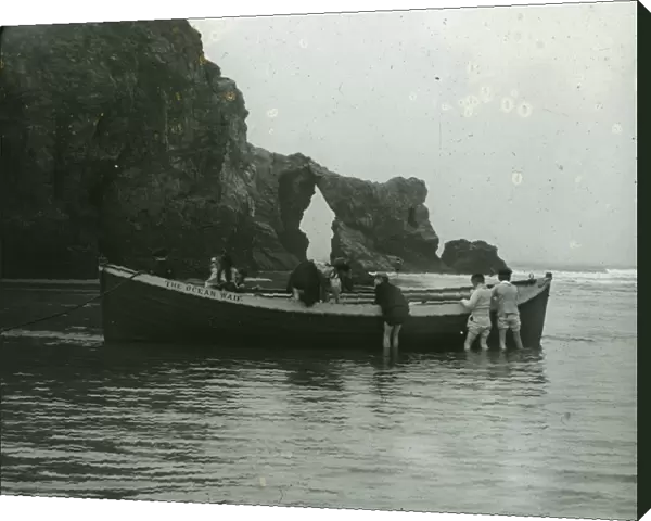 Retreat Rocks with children playing on the boat The Ocean Waif, Perranporth, Cornwall. Around 1925