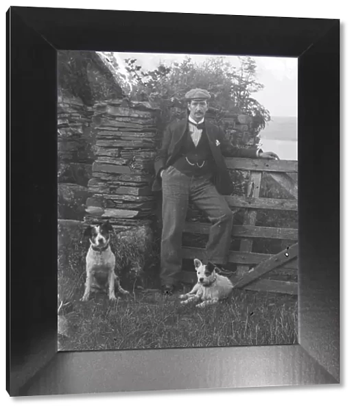 Man with two dogs posed by gateway at St Saviours Point, Padstow, Cornwall. Early 1900s