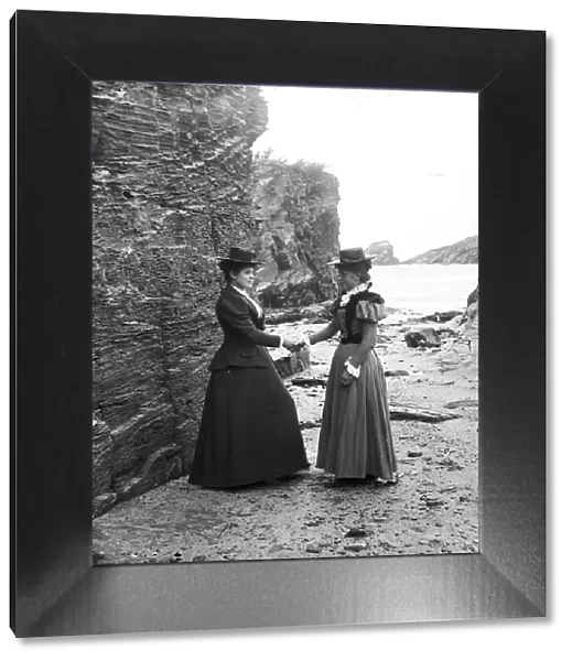 Two women below the cliff at Trevone, Padstow, Cornwall. Probably 1890s or early 1900s