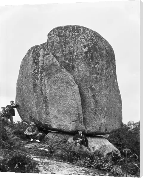 Three men by near a huge granite boulder, Luxulyan Valley, Cornwall. 1900