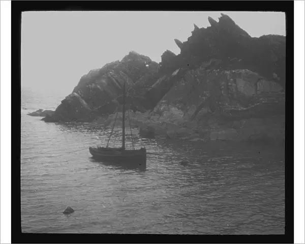 Fishing boat in a cove, probably Polperro, Cornwall. Around 1900