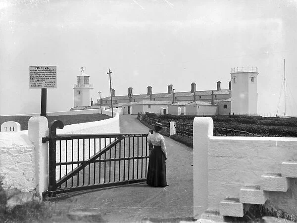 Close up view of Lizard lighthouse with a lady at the gate, Landewednack, Cornwall. Around 1905