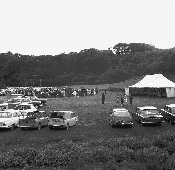 A crowd of people gathering to watch a Cornish wrestling match at an unknown location, Cornwall. 1970