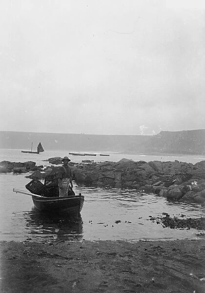 Dinghy with fisherman and lobster pots, Cornwall. Around 1900