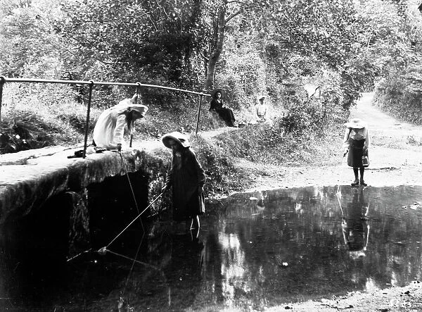 Three girls fishing in the River Kenwyn at the ford and footbridge, Treliske Lane, Newmills, Kenwyn, Cornwall. Early 1900s