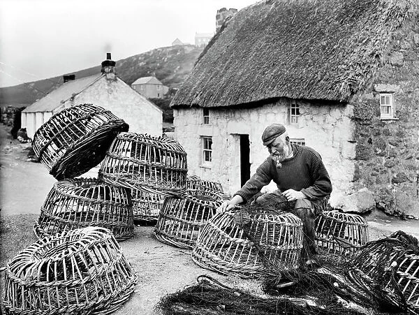 Bill Harvey inspecting fishing nets, Porthgwarra, Cornwall. June 1903