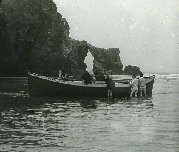 Retreat Rocks with children playing on the boat The Ocean Waif, Perranporth, Cornwall. Around 1925