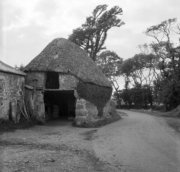 Thatched cob building by roadside, Lanarth, St Keverne, Cornwall. 1971