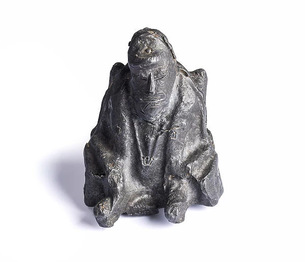 Tin Figurine. A seated figurine made from tin, with a little zinc