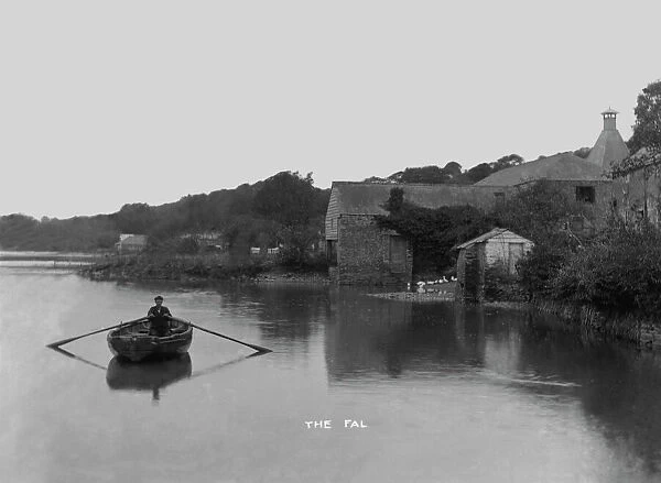 Village from the river with man rowing, Tresillian, Cornwall. 1890s