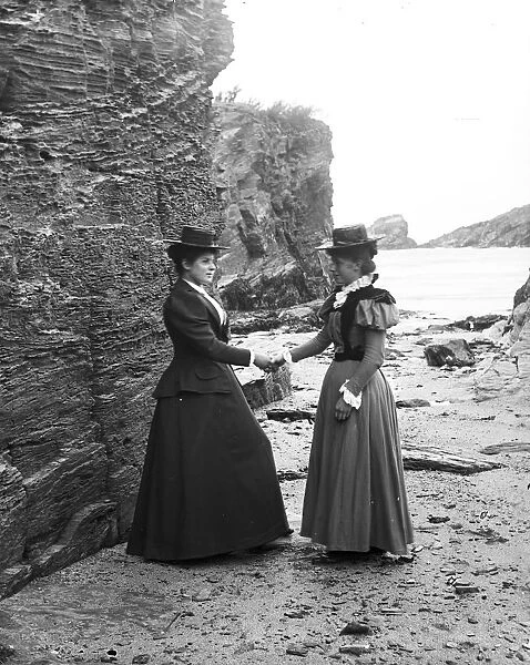 Two women below the cliff at Trevone, Padstow, Cornwall. Probably 1890s or early 1900s