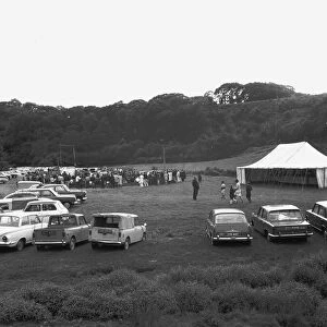 A crowd of people gathering to watch a Cornish wrestling match at an unknown location, Cornwall. 1970