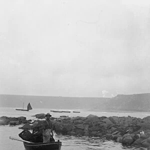 Dinghy with fisherman and lobster pots, Cornwall. Around 1900