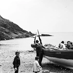 Fishermen launching a boat at Portloe, Veryan, Cornwall. July 1912