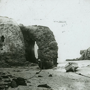 Perranporth Arch Rock, with boats on the beach, Cornwall. Around 1925
