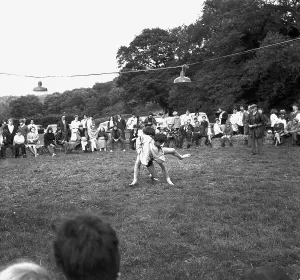 A crowd of people gathered to watch a Cornish wrestling match at an unknown location, Cornwall. 1970