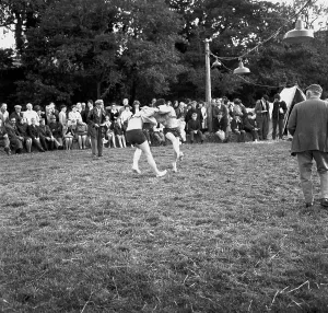 A crowd of people gathered to watch a Cornish wrestling match at an unknown location, Cornwall. 1970