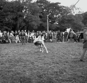 A crowd of people gathered to watch a Cornish wrestling match at an unknown location, Cornwall. 1970
