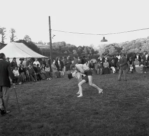 A crowd of people gathered to watch a Cornish wrestling match at an unknown location, Cornwall. 1970