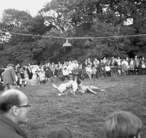 A crowd of people gathered to watch a Cornish wrestling match at an unknown location, Cornwall. 1970