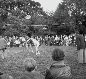 A crowd of people gathered to watch a Cornish wrestling match at an unknown location, Cornwall. 1970