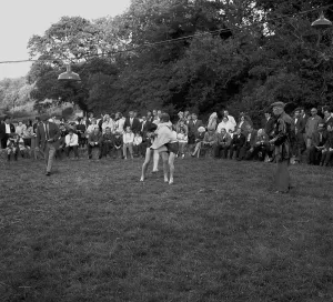 A crowd of people gathered to watch a Cornish wrestling match at an unknown location, Cornwall. 1970