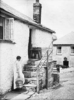 Port Gaverne Collection: Teresa Mallett on cottage steps carrying a wooden barrel pail